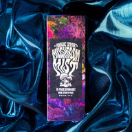 Mystic Dust product packaging on a blue satin background