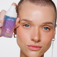 Woman holding a bottle of 'Magic Star' hair product against a white background